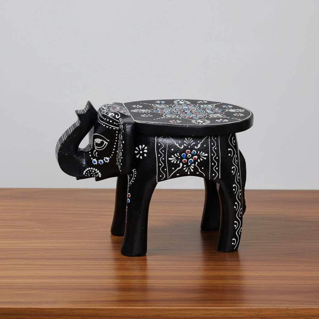 Decorative black wooden elephant stool featuring traditional hand-painted artwork and intricate embossed detailing, ideal for ethnic and contemporary home décor.
