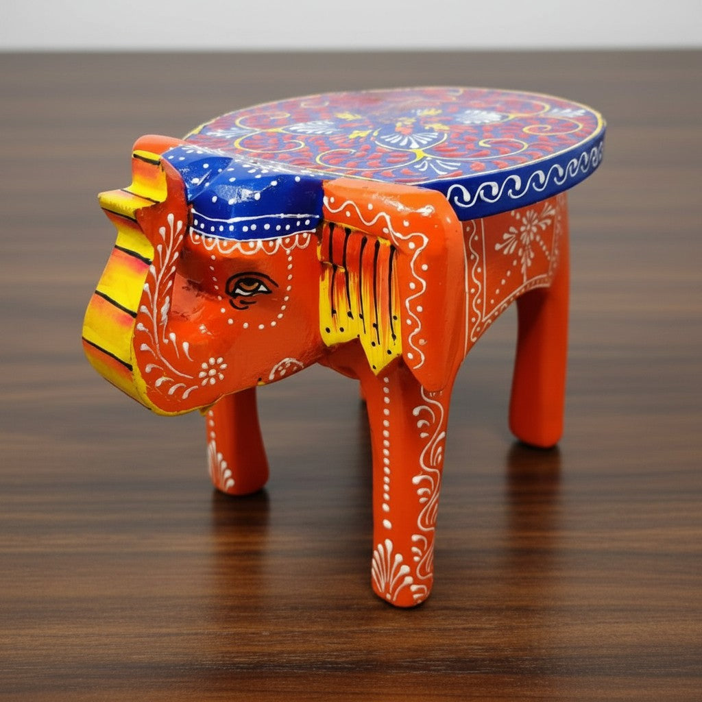 Artisan-crafted orange wooden elephant stool with vibrant painted patterns, suitable for plant stands, side tables, and collectible displays.