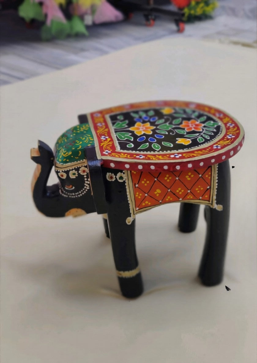 "Handcrafted embossed painted wooden elephant stool featuring vibrant multicolor artwork and traditional ethnic detailing. Perfect as a decorative animal showpiece, plant stand, side stool, or accent piece for living rooms, entryways, bedrooms, and bohemian home décor. Supports up to 15 kg."