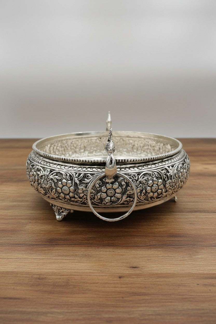 Traditional German silver peacock urli bowl with carved antique design, elegant festive décor accent for floating flowers, candles, and cultural celebrations.